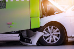 car wedged under a bus