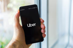 male hand gripping a phone with the Uber app loaded