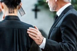 man comforting a woman at a funeral