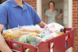 man delivering an armful of groceries