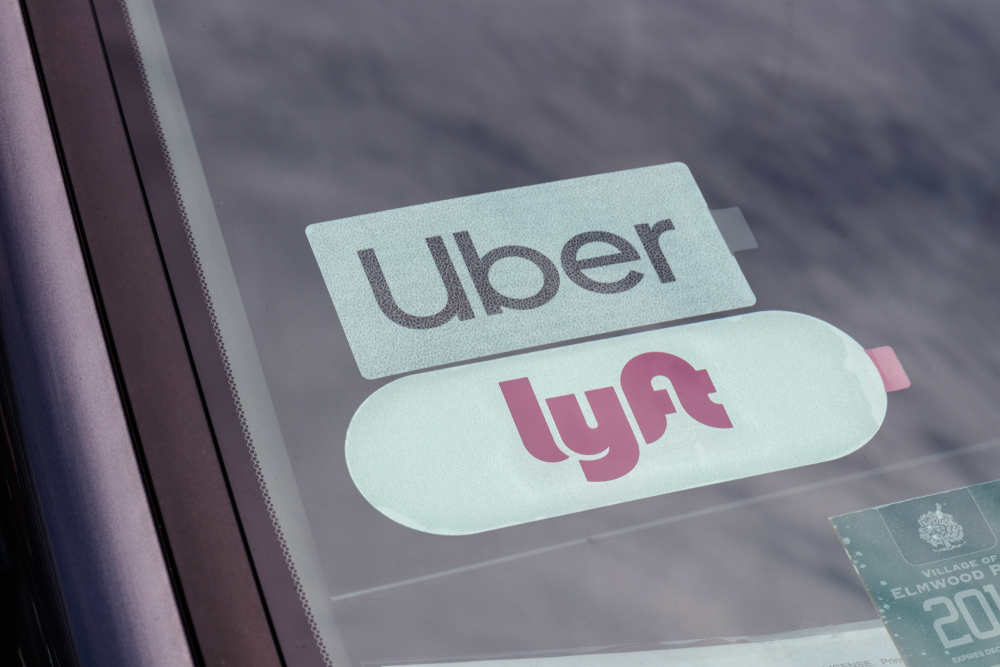 Uber and Lyft stickers in the back window of a car