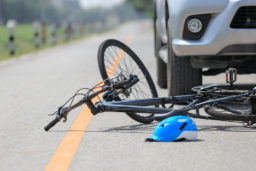 bicycle and helmet in the road near a car