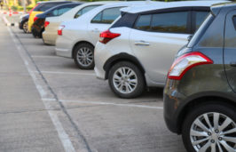 the rear-ends of cars in a parking lot