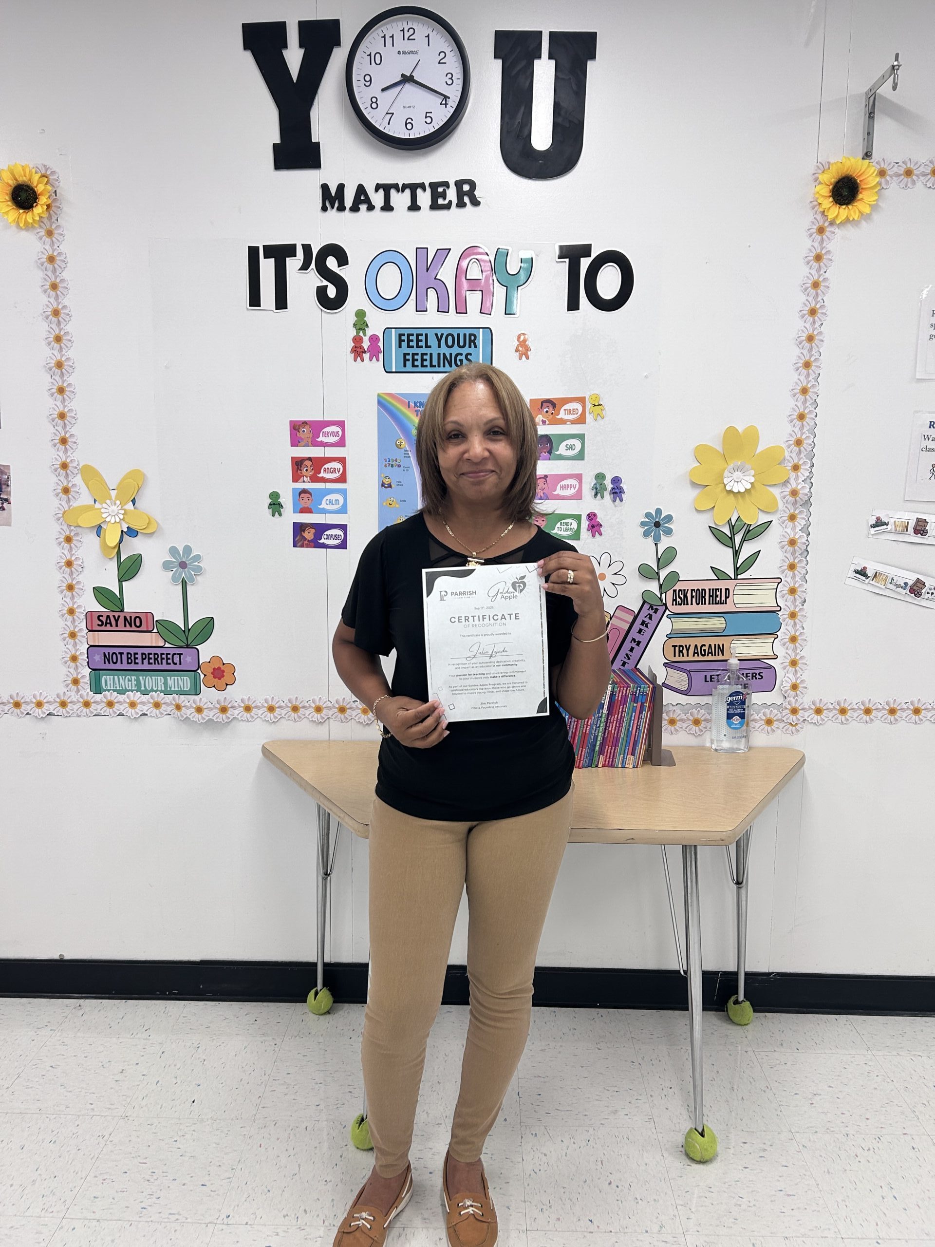 Julia T holding Golden Apple Program certificate of recognition